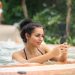 Photo of a woman in jacuzzi using smartphone